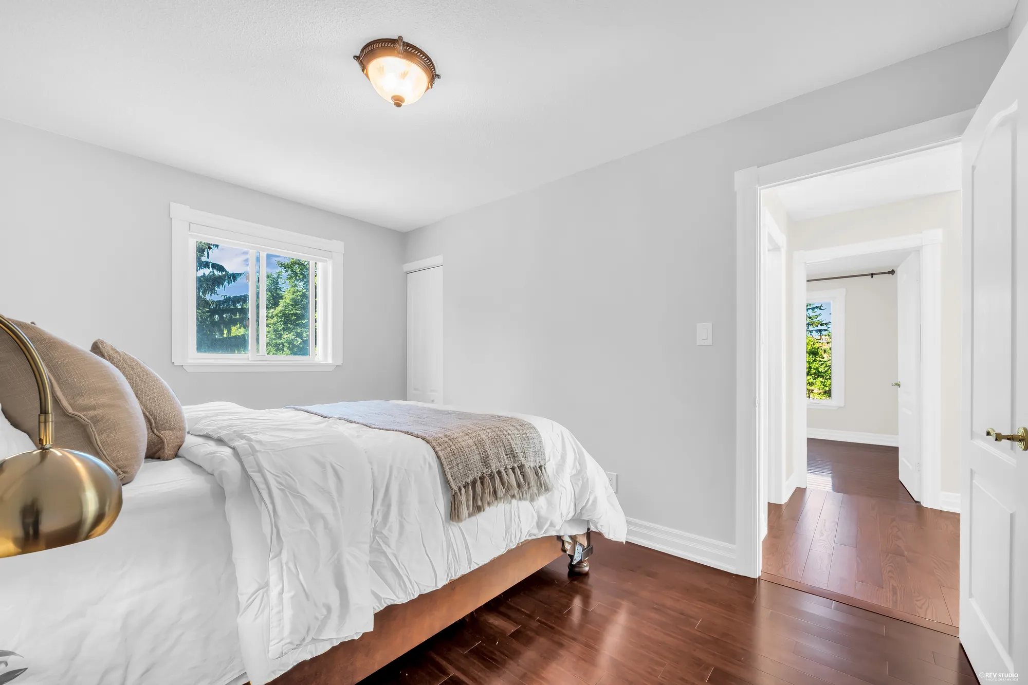 The same bedroom toward its window and the door to the hall